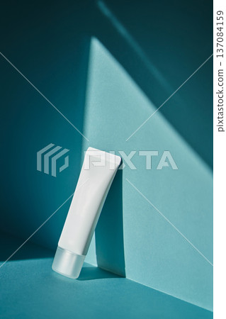 White cosmetic tube mockup on teal background White cosmetic tube mockup on teal background 137084159