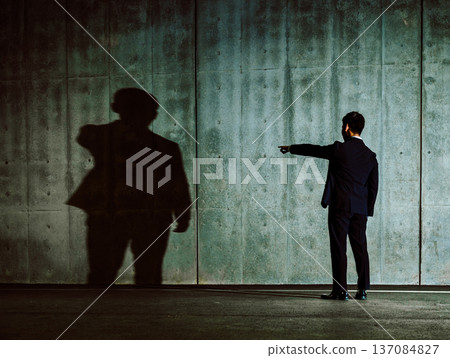 Shadow and a man in a suit pointing 137084827