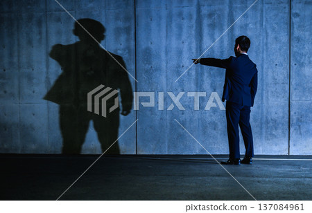 A man in a suit confronting a shadow 137084961