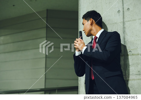 A man in a suit holds a gun 137084965