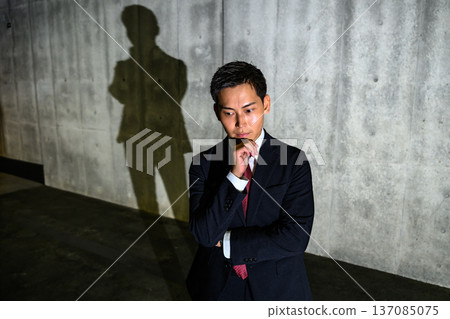 A man in a suit is deep in thought A man in a suit is deep in thought 137085075