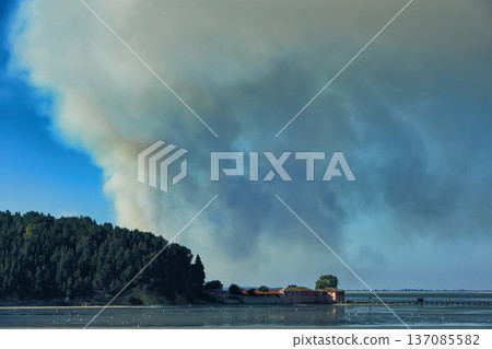 A distant wildfire sends a towering column of smoke into the sky above a small coastal island near Vlora, Albania, captured on August 25, 2025. A distant wildfire sends a towering column of smoke into the sky above a small coastal island near Vlora, Albania, captured on August 25, 2025. 137085582