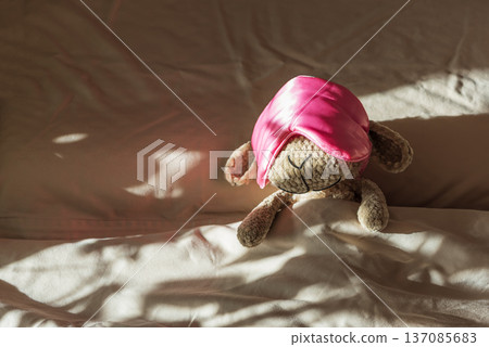Knitted Sheep Toy Sleeping with Satin Mask on Cozy Bed under Morning Sunlight Knitted Sheep Toy Sleeping with Satin Mask on Cozy Bed under Morning Sunlight 137085683