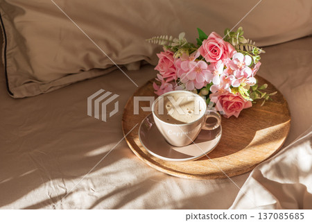Cappuccino Cup and Flowers on Tray with Satin Bedding in Sunlight. Valentine's or Mother's Day Celebration Cappuccino Cup and Flowers on Tray with Satin Bedding in Sunlight. Valentine's or Mother's Day Celebration 137085685