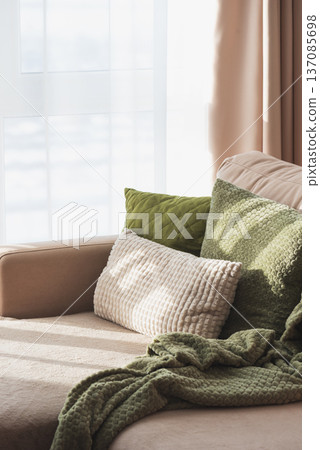 Textured Pillows and Blanket on Sofa. Cozy Spring Home Interior with Natural Light Textured Pillows and Blanket on Sofa. Cozy Spring Home Interior with Natural Light 137085698