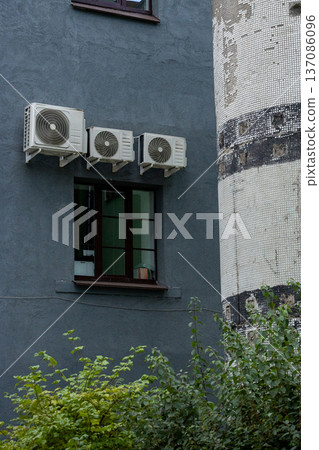 air conditioning on facade of building, air cooling in hot weather. air conditioning on facade of building, air cooling in hot weather. 137086096