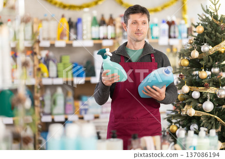 Man chooses spray glass cleaner and detergent in supermarket before Christmas Man chooses spray glass cleaner and detergent in supermarket before Christmas 137086194