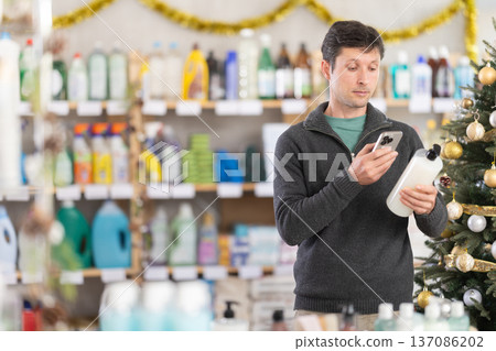 Checking expiration date of shower gel or champoo - male shopper scans QR code on label of shower gel or champoo using smartphone Checking expiration date of shower gel or champoo - male shopper scans QR code on label of shower gel or champoo using smartphone 137086202