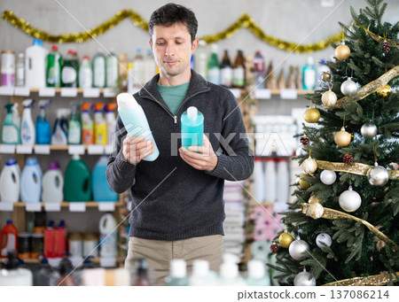 Adult man choosing shampoo or shower gel in decorated store Adult man choosing shampoo or shower gel in decorated store 137086214