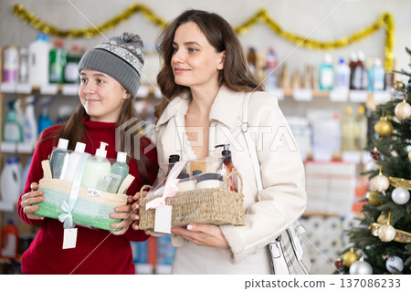 Happy girl with mother choosing holiday self-care gift boxes Happy girl with mother choosing holiday self-care gift boxes 137086233