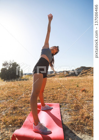 Yoga practice on a pink mat in the mountains Yoga practice on a pink mat in the mountains 137086466
