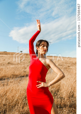 Beautiful woman in red dress with raised arms in Calabria region Beautiful woman in red dress with raised arms in Calabria region 137086467