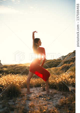 Golden hour light on woman in red dress dancing in Sicily Golden hour light on woman in red dress dancing in Sicily 137086468