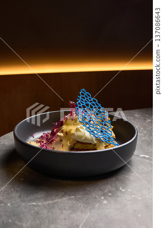 Exquisite plated dessert with unique blue decoration and delicate cream presentation, gourmet dining concept 137086643