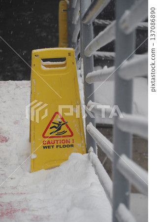 Caution sign shows wet floor during snow weather Caution sign shows wet floor during snow weather 137086890