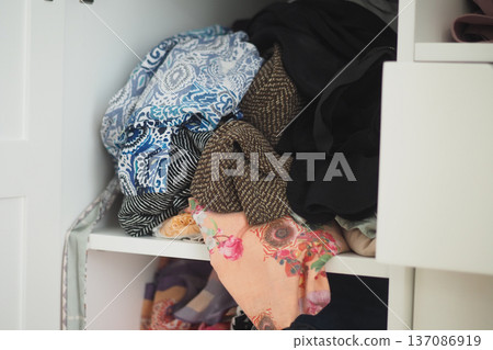Clothes piled in a small closet on a home organization day 137086919