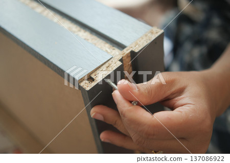 Hand skilled worker assembling furniture parts in workshop 137086922