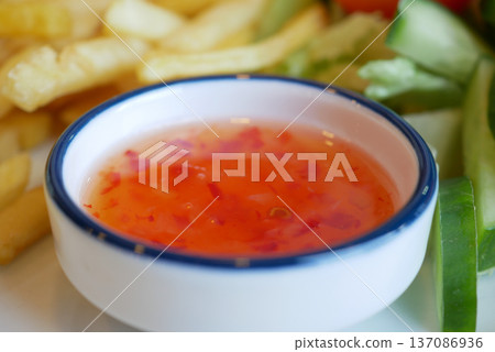 Sauce and sides served with fries and vegetables for dipping Sauce and sides served with fries and vegetables for dipping 137086936