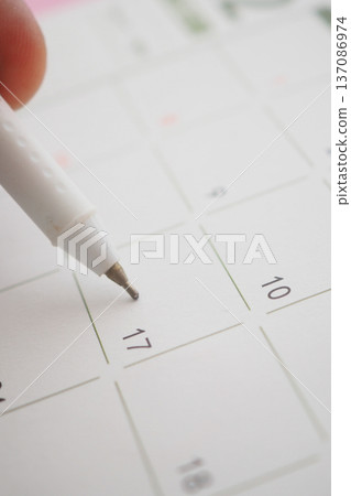 Marking a date on a calendar with a pen Marking a date on a calendar with a pen 137086974