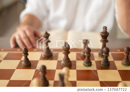 Close up of hands of middle aged caucasian man playing chess.  137087722