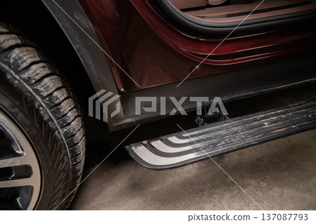 Folding step of a red modern car.  137087793