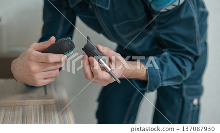 An electrician holds a broken screwdriver. An electrician holds a broken screwdriver. 137087930