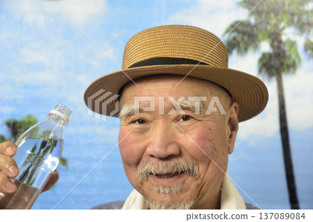 一位老年人正在補充水分以預防中暑。 一位老年人正在補充水分以預防中暑。 137089084