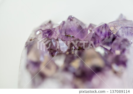 The crystal cluster shows multiple purple crystals with different shapes. The sunlight highlights the unique details and textures of the stones. This scene shows natural beauty and geology. The crystal cluster shows multiple purple crystals with different shapes. The sunlight highlights the unique details and textures of the stones. This scene shows natural beauty and geology. 137089114