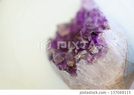 Amethyst crystals are displayed in a close-up view highlighting their distinct shapes and shades of purple. The natural light reflects off the facets, showcasing their beauty. Amethyst crystals are displayed in a close-up view highlighting their distinct shapes and shades of purple. The natural light reflects off the facets, showcasing their beauty. 137089115