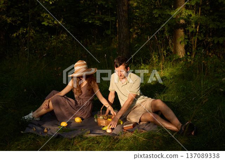 Sunset light bathes couple sharing casual outdoor meal happily 137089338