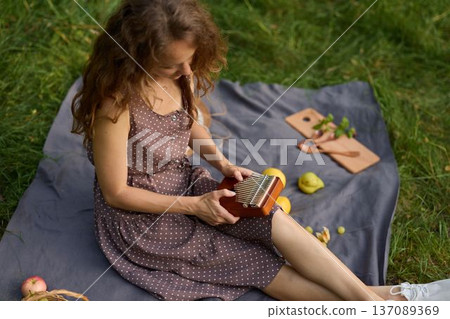Woman engages with book amidst bright grass field 137089369