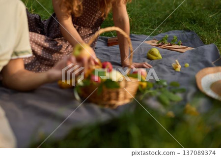 Lady adds fruit, Female carefully places apples in basket outdoors Lady adds fruit, Female carefully places apples in basket outdoors 137089374