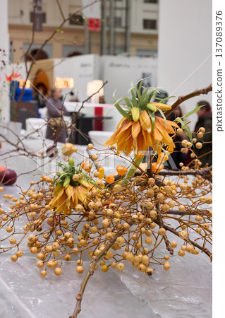 Artisan styled orange fritillaria with golden berries closeup 137089376