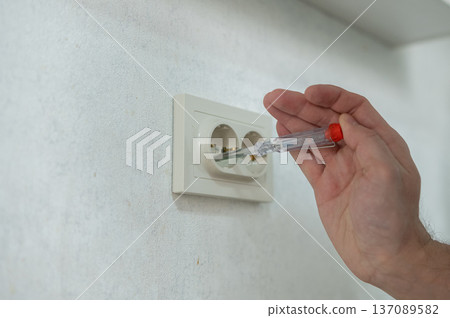 The technician determines the voltage in the socket. The technician determines the voltage in the socket. 137089582