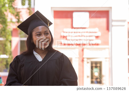 Happy young african woman in graduation gown. Happy young african woman in graduation gown. 137089626