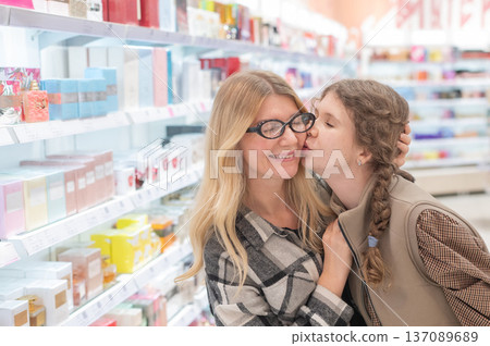 A mother and her teenage daughter are shopping for cosmetics. A mother and her teenage daughter are shopping for cosmetics. 137089689