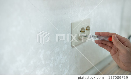 The technician determines the voltage in the socket. The technician determines the voltage in the socket. 137089719