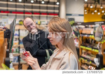 A Caucasian couple shopping at a cosmetics store.  137089720