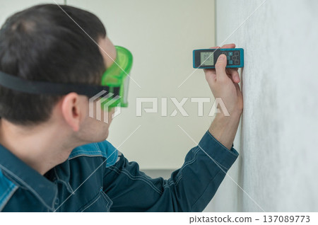 The master uses a laser tape measure. The master uses a laser tape measure. 137089773