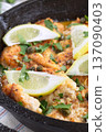 Haddock fish piccata with lemon and capers in cast iron pan, vertical closeup 137090403