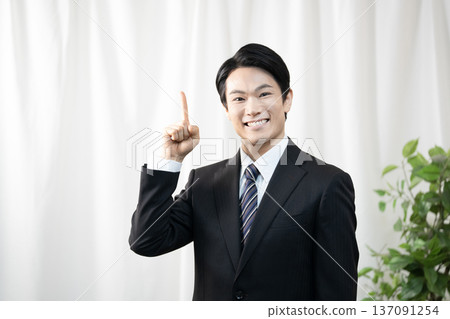 Businessman raising index finger 137091254