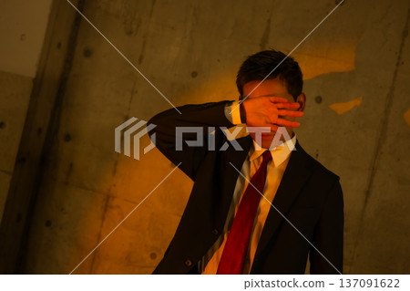 身穿西裝的男子摀著臉 137091622