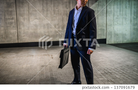 A man in a suit holds a bag A man in a suit holds a bag 137091679