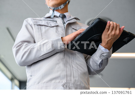 Work clothes and tablet operation Work clothes and tablet operation 137091761