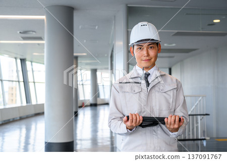 A man in work clothes stands A man in work clothes stands 137091767