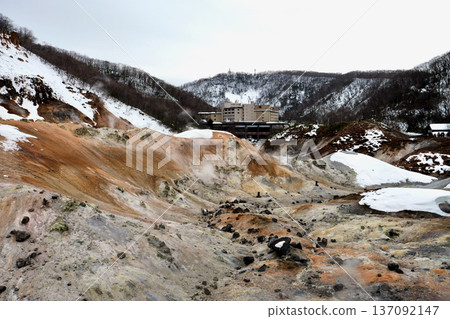 Noboribetsu Jigokudani in winter: White snow and brown mountainside, with a hot spring town in the background Noboribetsu Jigokudani in winter: White snow and brown mountainside, with a hot spring town in the background 137092147