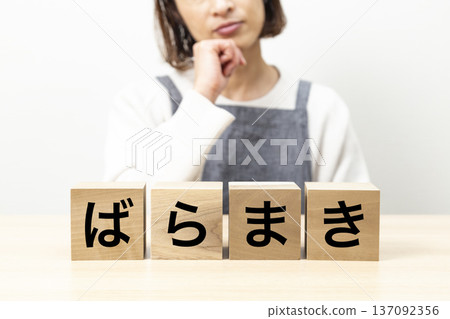 一位身穿圍裙的女士正擔心一塊寫著「散落」字樣的磚塊。 137092356
