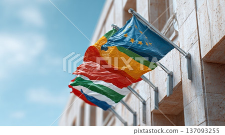 Flags from different countries. Including a supranational flag. Are waving gently in the wind. Attached to a modern building. Symbolizing international cooperation. Diplomacy. And global partnerships 137093255