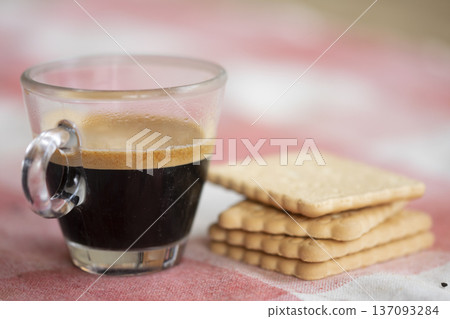 breakfast concept with an espresso coffee next to cookies on pink background 137093284