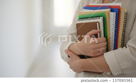 Student Clutching Notebooks In Bright Corridor, Closeup Of Hands And Stack Of Folders, Soft Hallway Light And Blurred Background, Posture Conveys Readiness For Tutorial Or Office Hours, Student Clutching Notebooks In Bright Corridor, Closeup Of Hands And Stack Of Folders, Soft Hallway Light And Blurred Background, Posture Conveys Readiness For Tutorial Or Office Hours, 137093361